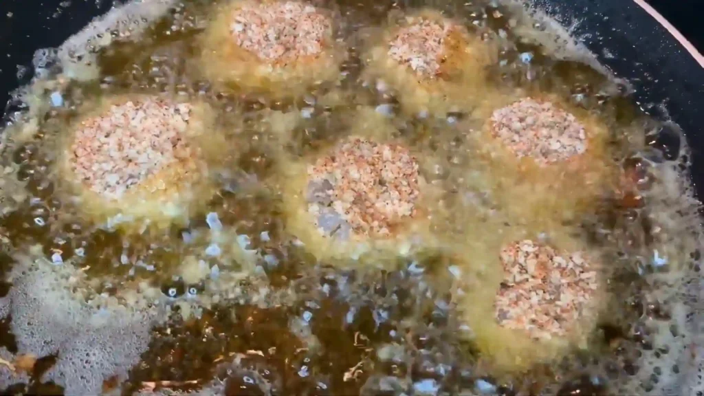 Boom Boom Shrimp frying in hot oil, creating a crispy golden crust.