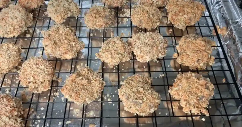 Breaded Boom Boom Shrimp pieces resting on a wire rack before cooking.