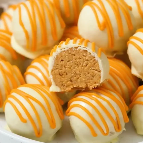 No-Bake Pumpkin Cheesecake Balls with white chocolate coating and orange drizzle